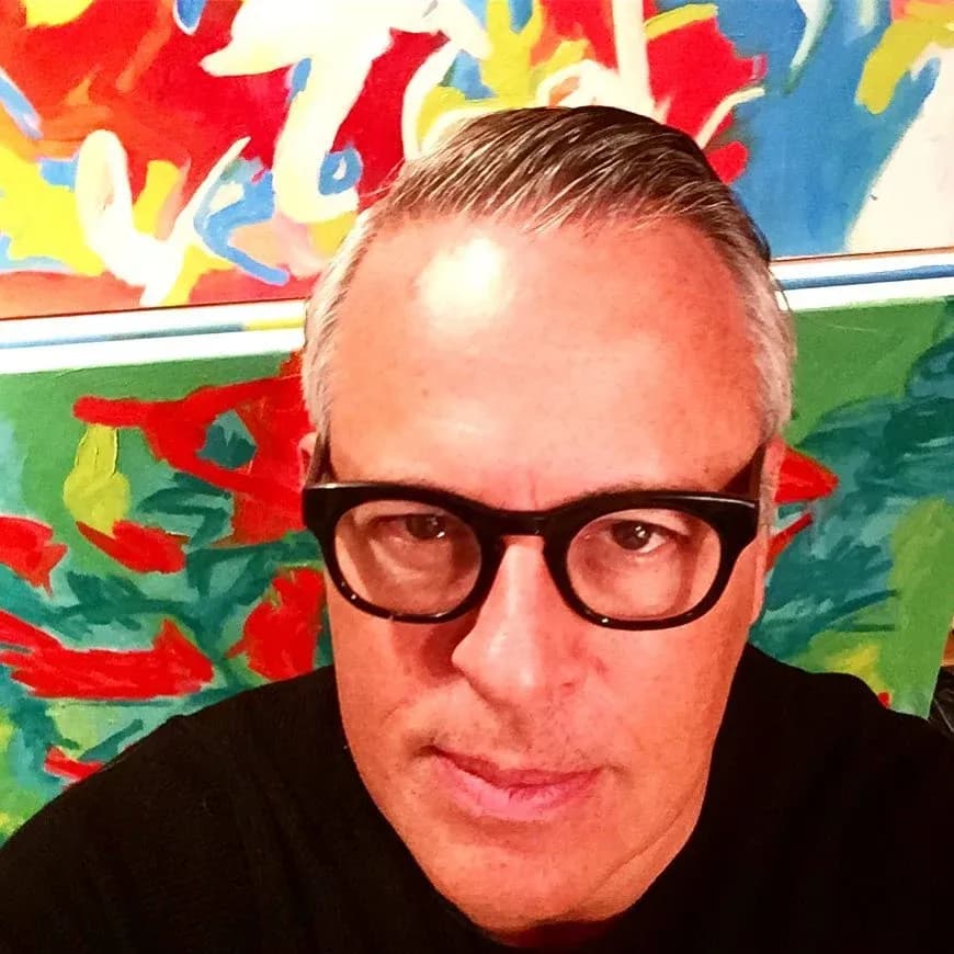 Steven W. Miller in front of his colorful abstract paintings